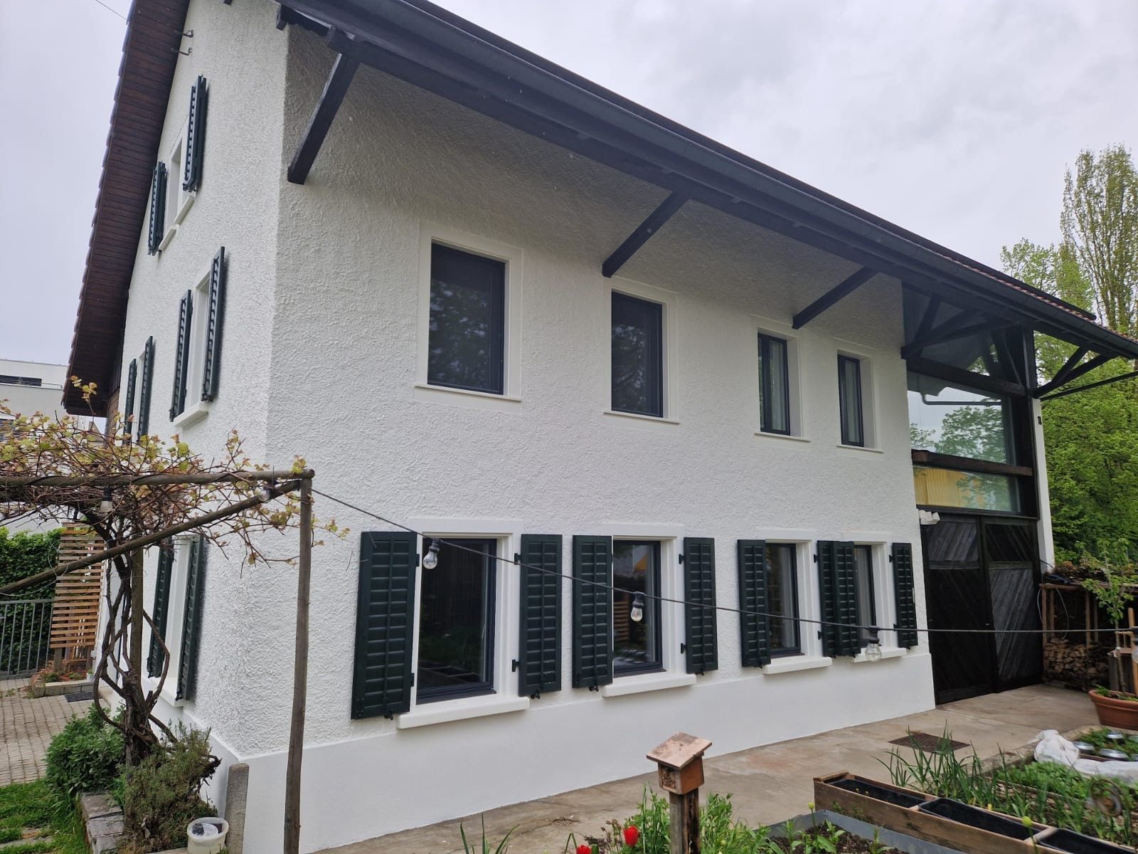 Ein weißes Haus mit schwarzen Fensterläden