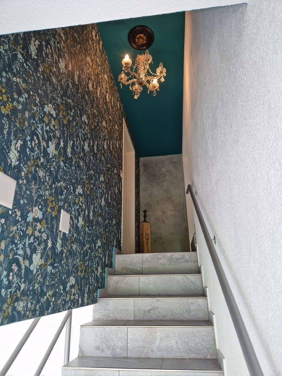 Eine Treppe mit einem Kronleuchter, der von der Decke hängt