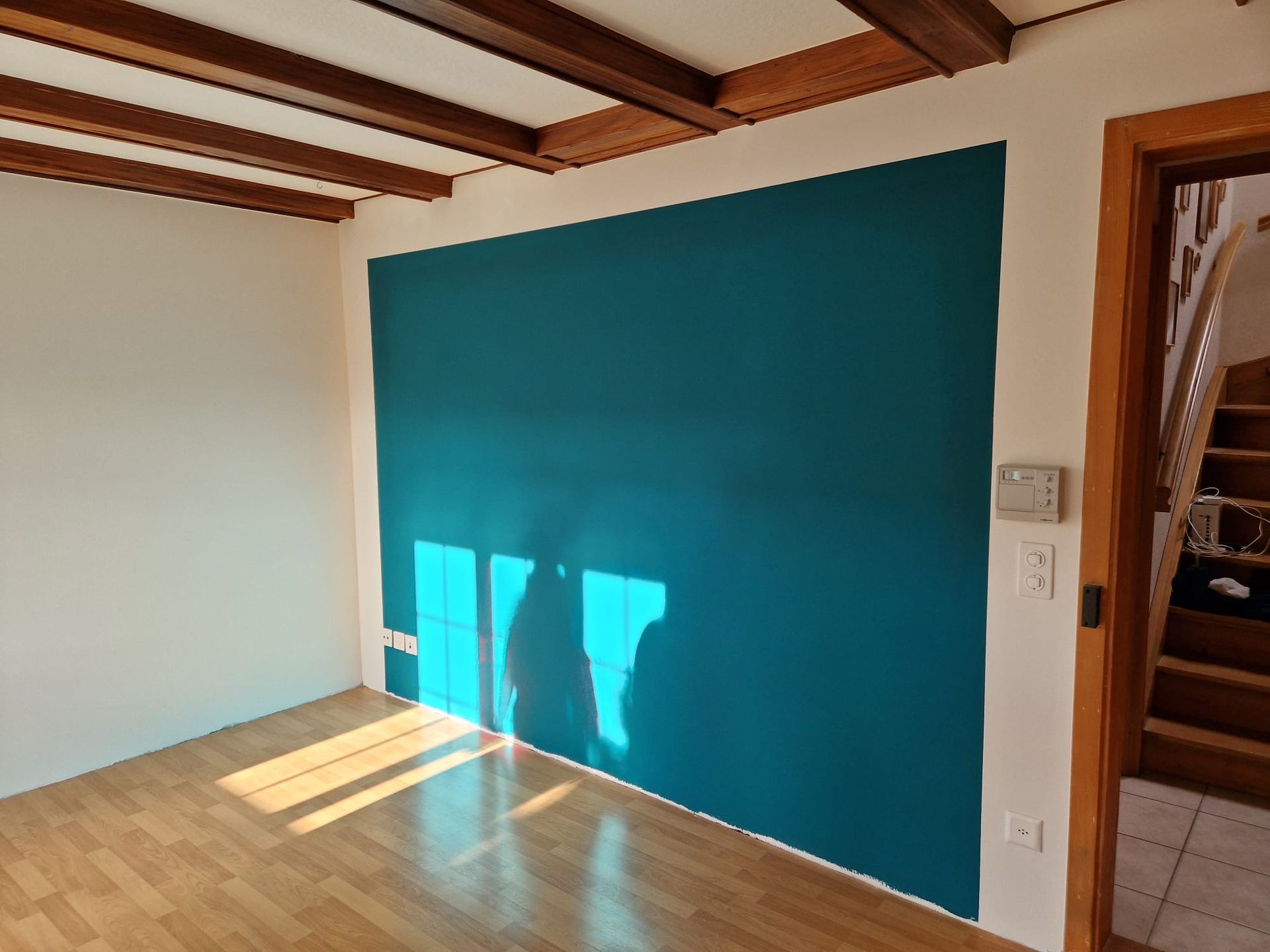 Ein Wohnzimmer mit einer blauen Wand und einem Holzboden.