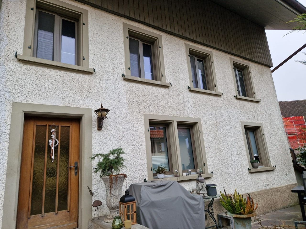 Ein weißes Haus mit vielen Fenstern und einer Tür.