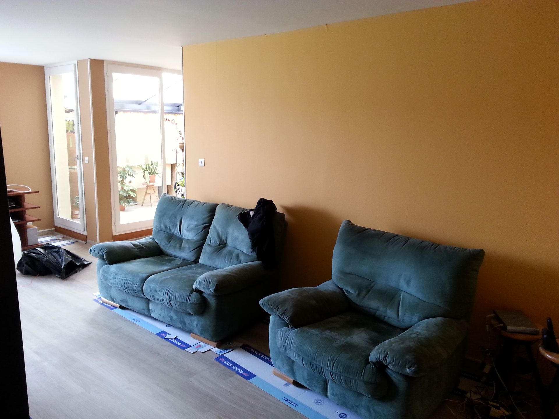 Une pièce avec des murs peints en jaune derrière des canapés