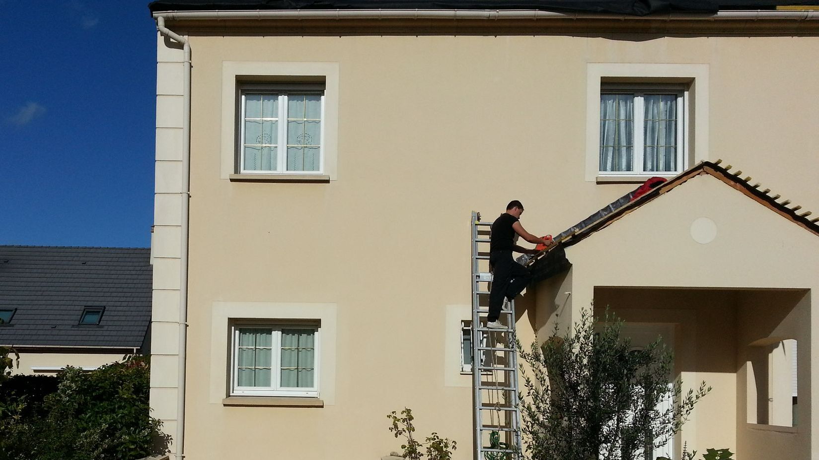 Une façade rénovée avec un peintre sur une échelle