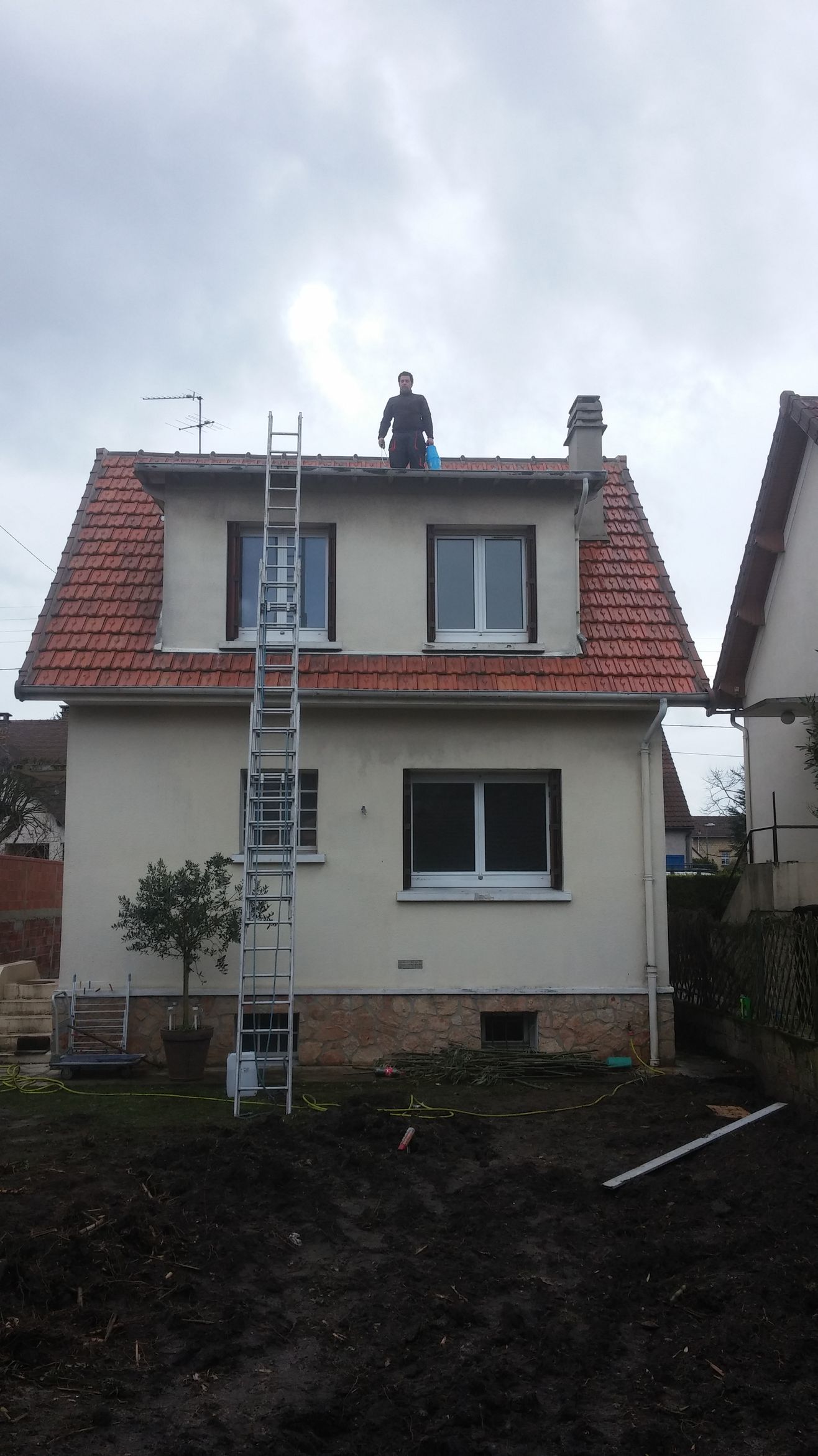 Une maison avec une échelle appuyée contre la façade