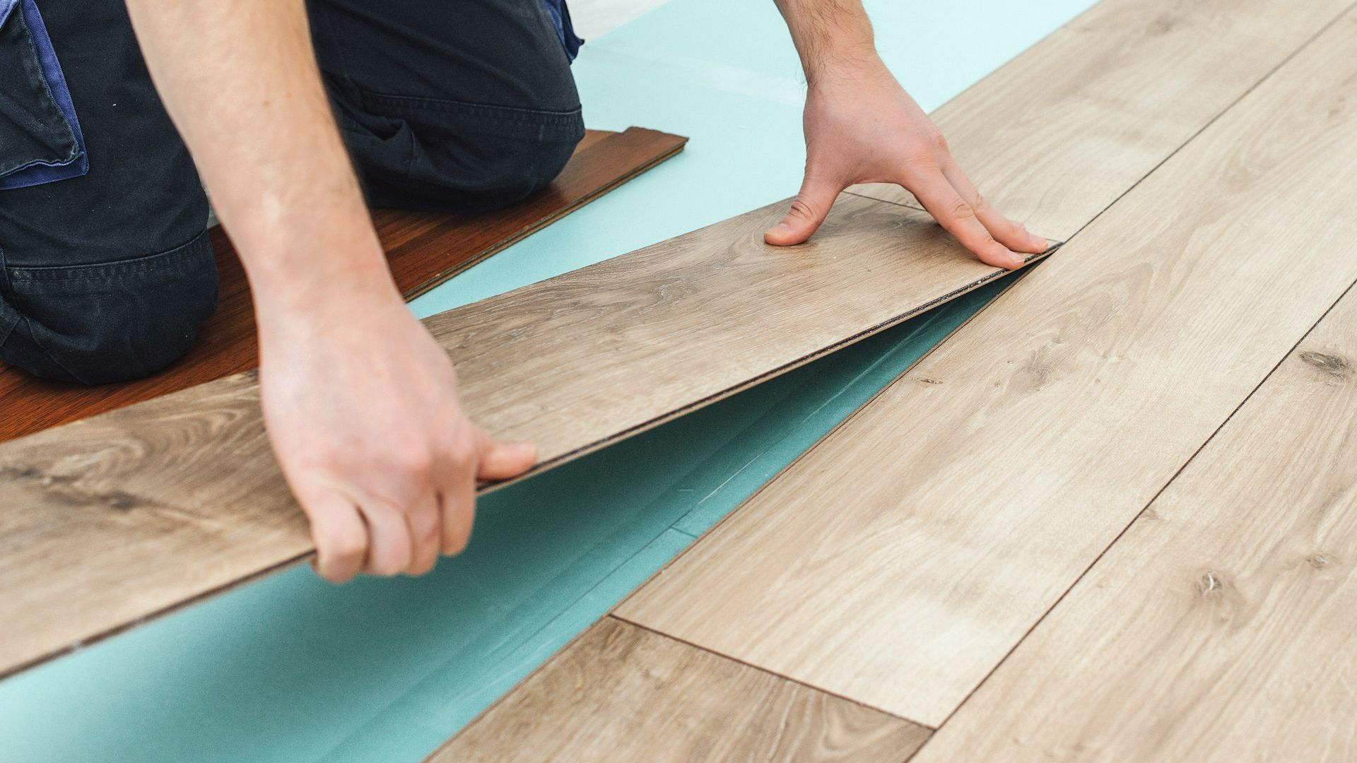 Un professionnel posant du parquet flottant