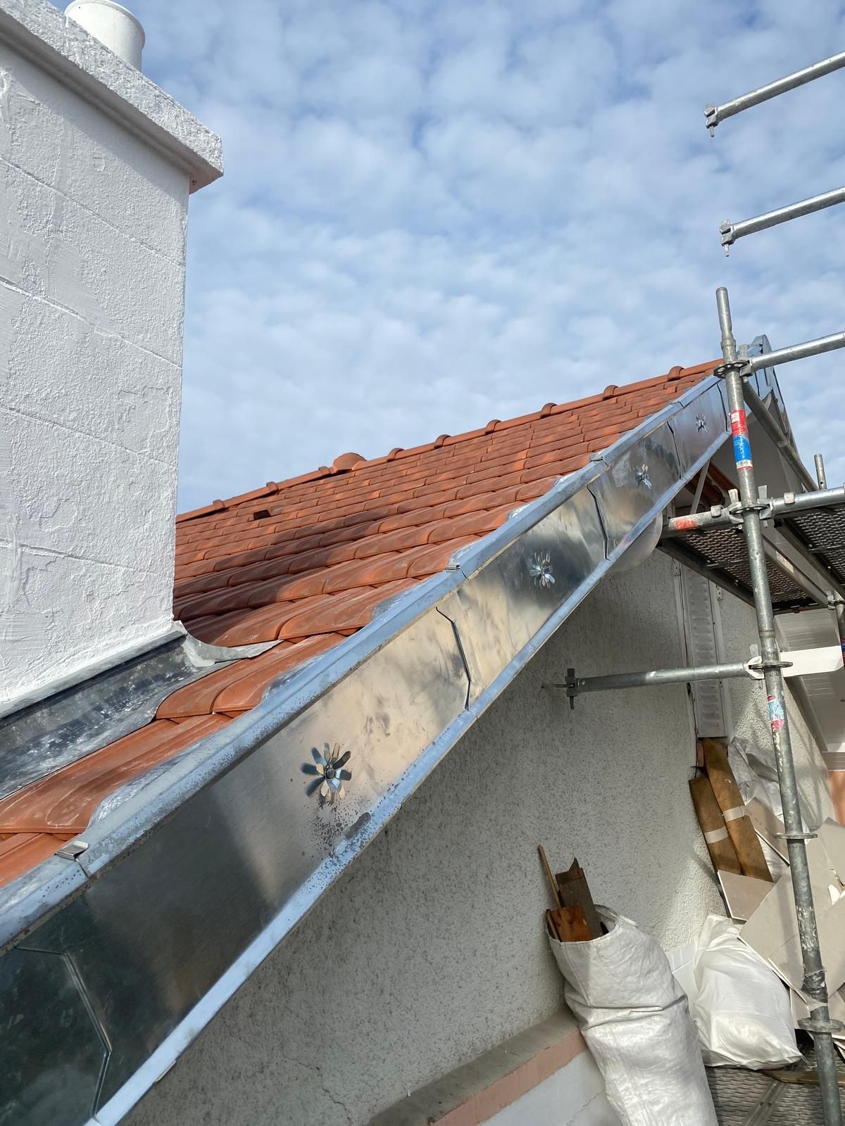 Des éléments de zinguerie sur une toiture en tuiles