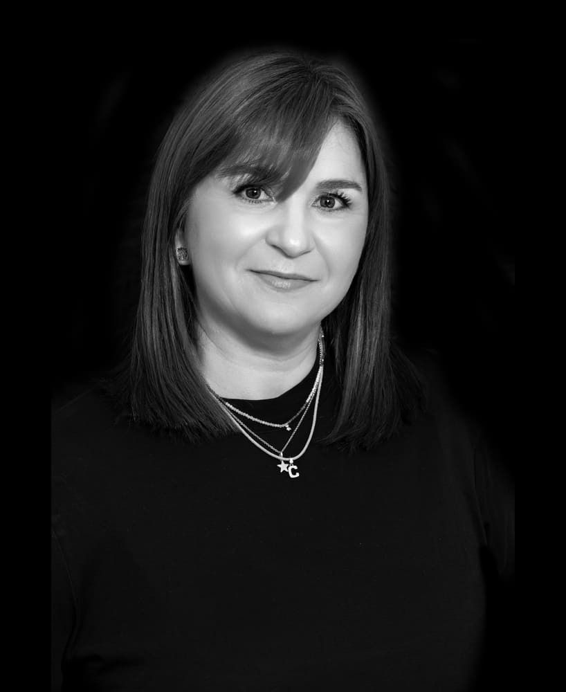Una fotografía en blanco y negro de una mujer que lleva un collar.