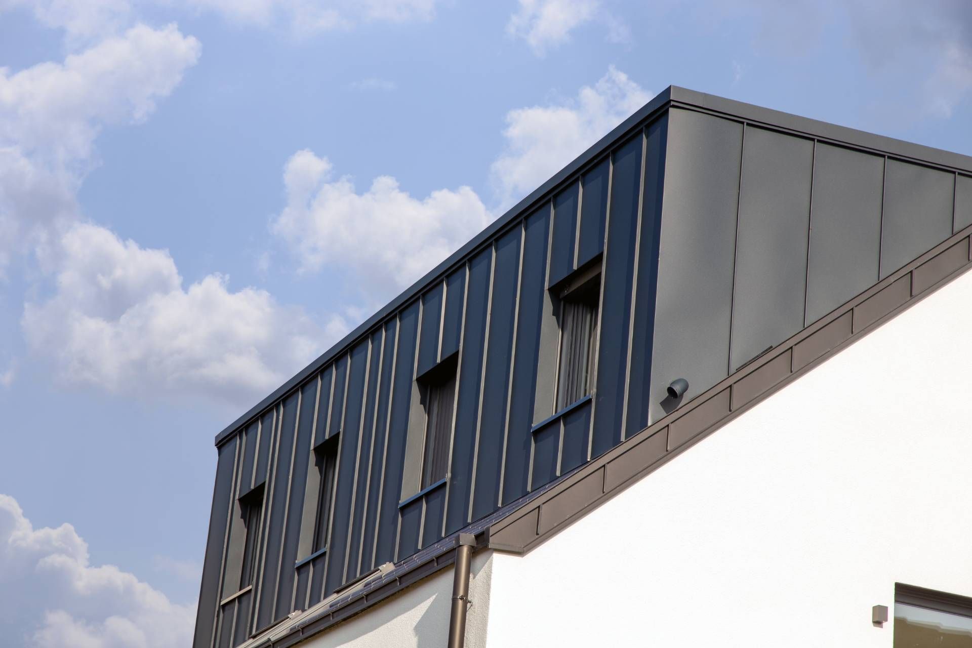 Das Dach eines Gebäudes mit einem blauen Himmel im Hintergrund.