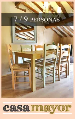 Una imagen de un comedor con una mesa y sillas.