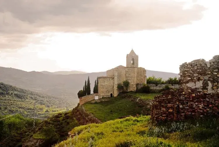 Una iglesia está situada en la cima de una colina en medio de un valle.