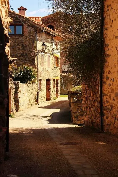 Un callejón estrecho entre dos edificios de piedra.