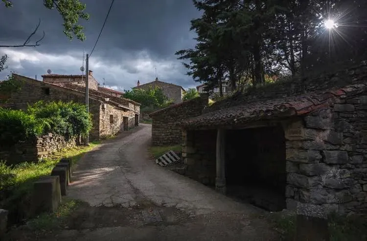 El sol brilla a través de las nubes sobre un pequeño pueblo.