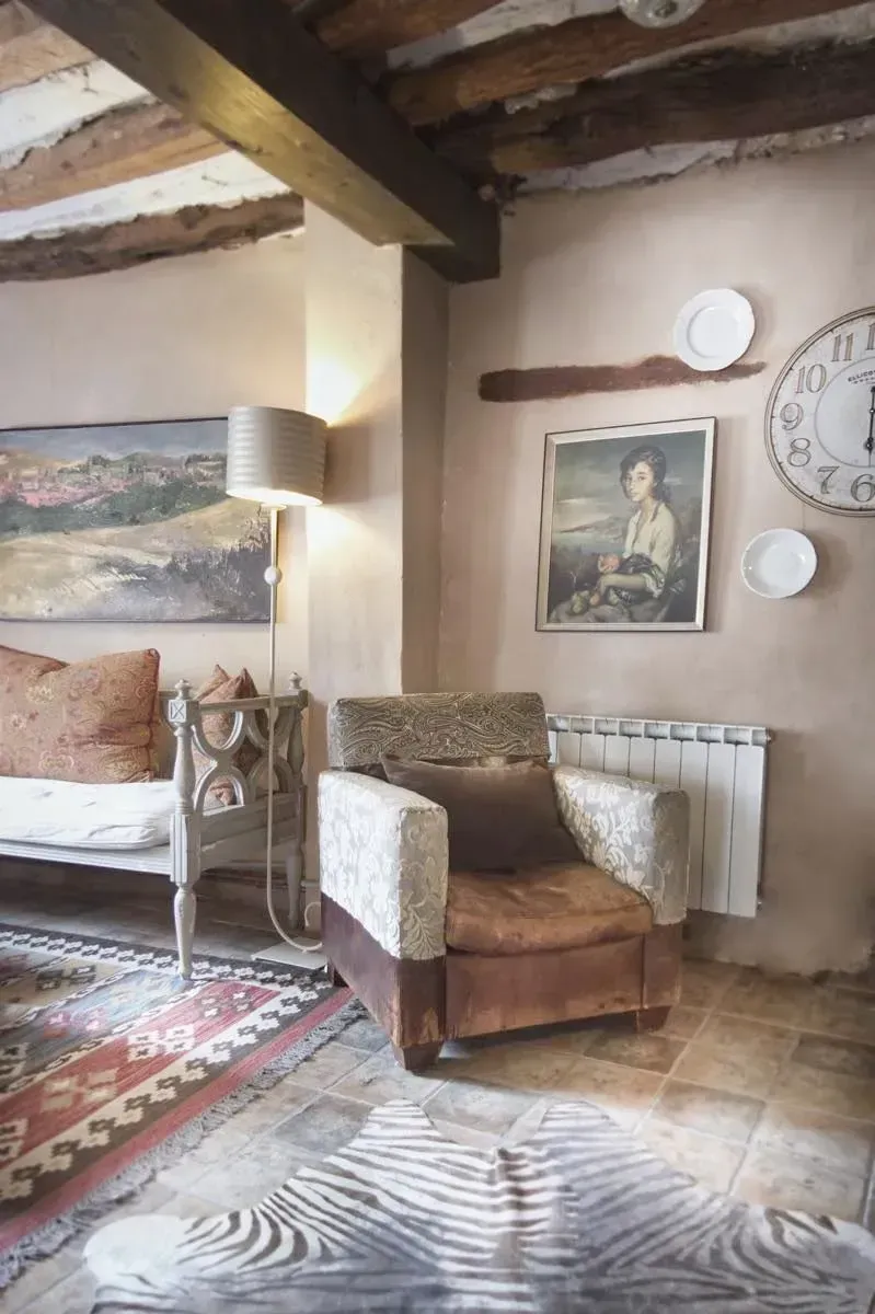 Acogedora sala de estar con un sillón marrón, alfombra, arte y una alfombra con estampado de cebra.