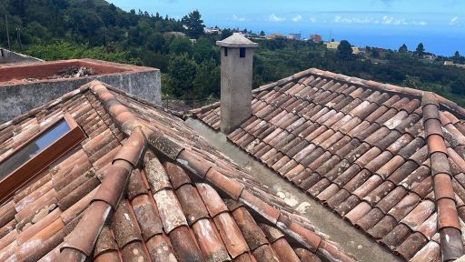 Un techo de tejas con una chimenea encima