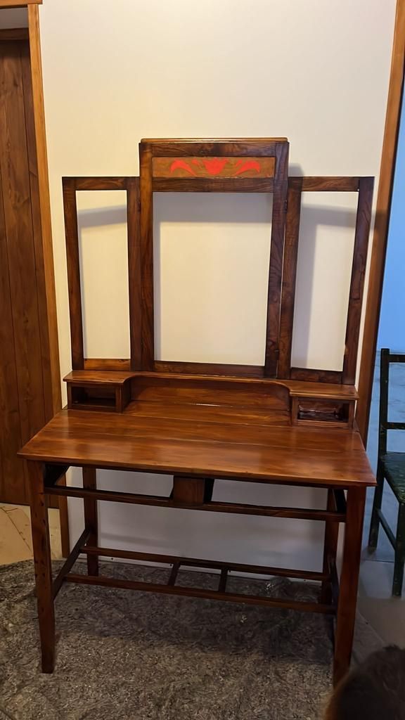 Un escritorio de madera con un espejo encima en una habitación.