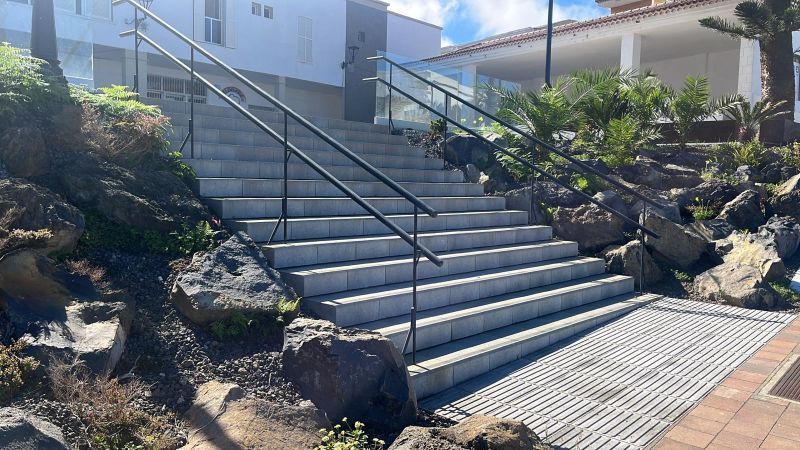 Un conjunto de escaleras que conducen a un edificio con barandilla.