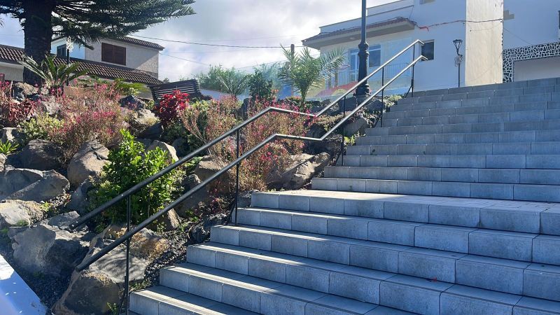 Un conjunto de escaleras que conducen a un edificio con una barandilla de metal.