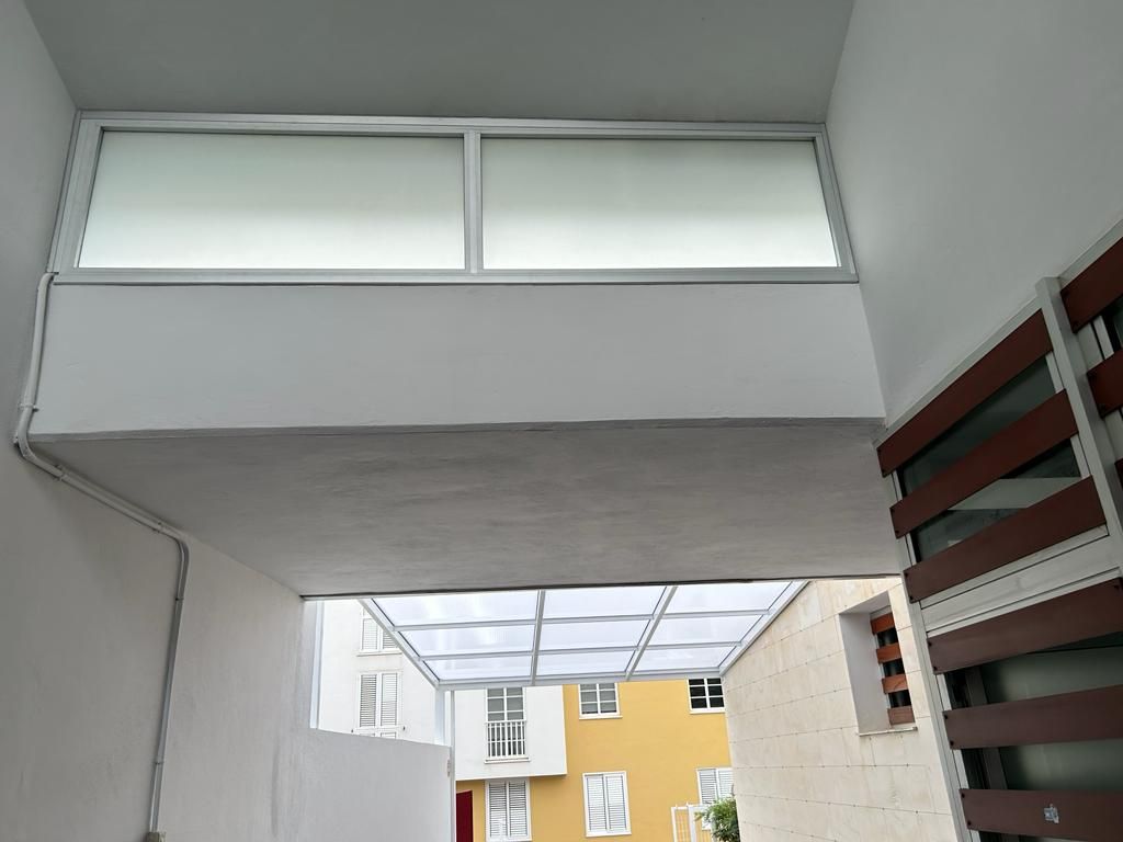 Un edificio blanco con un edificio amarillo al fondo.