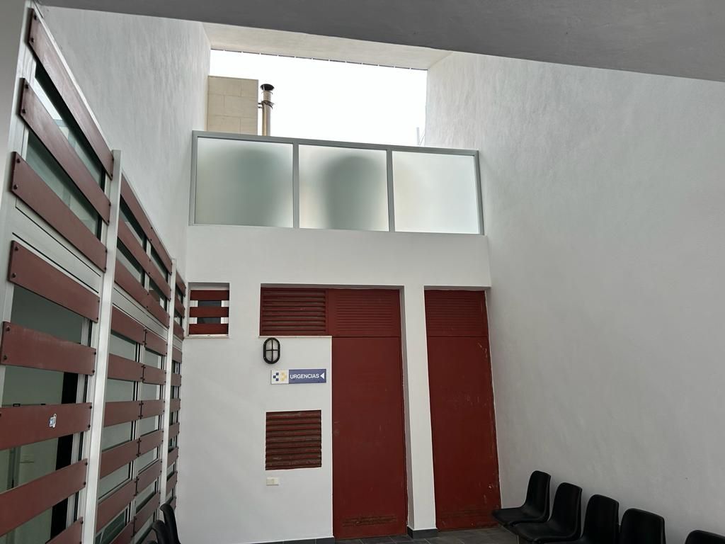 Una habitación con una puerta roja y una pared blanca