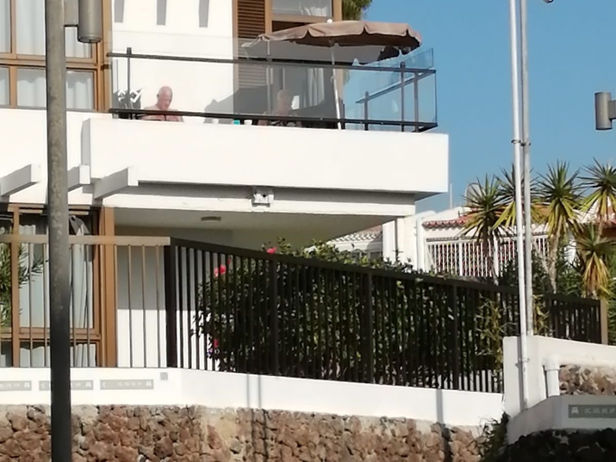 Una casa blanca con un balcón y una valla alrededor.