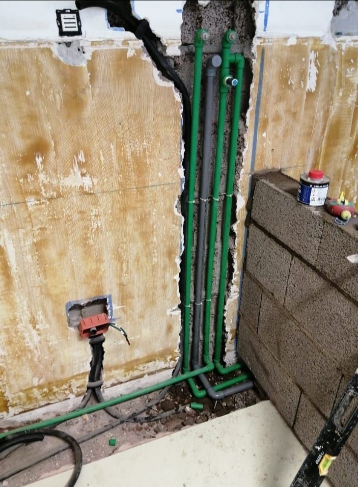 Una pared con un montón de tuberías saliendo de ella