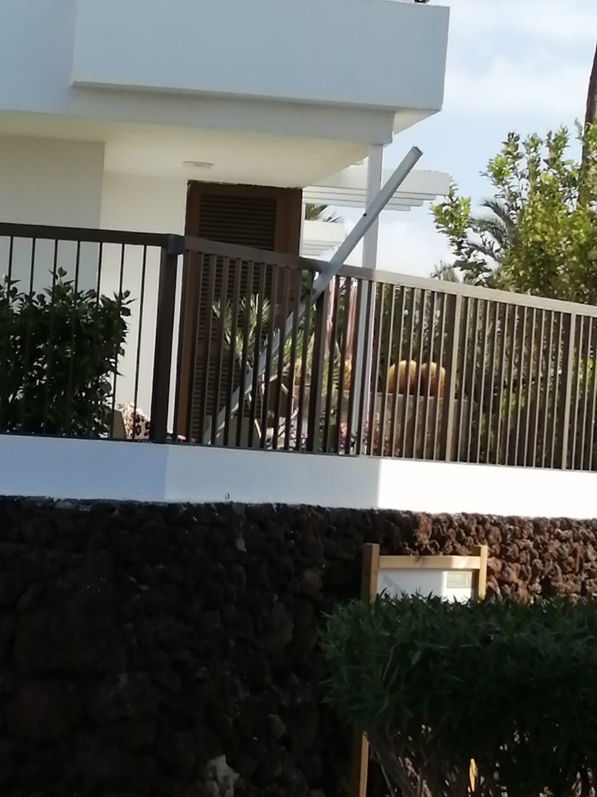 Una casa blanca con un balcón con barandilla de metal