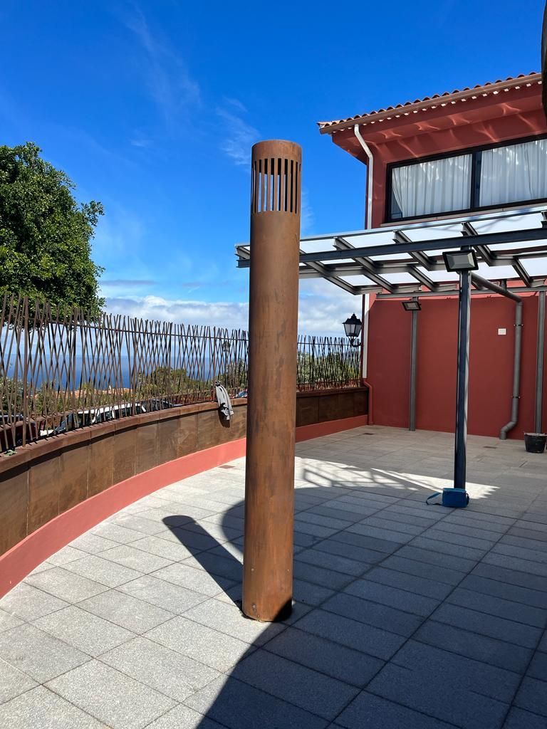 Un gran poste de madera se encuentra en un patio frente a un edificio.