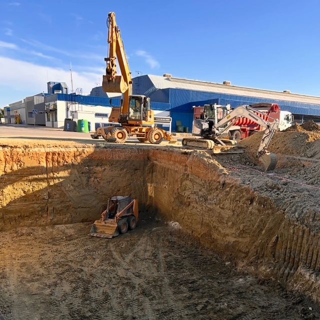 Una excavadora está cavando un hoyo en la tierra.
