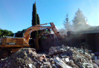 Una excavadora está demoliendo una casa.