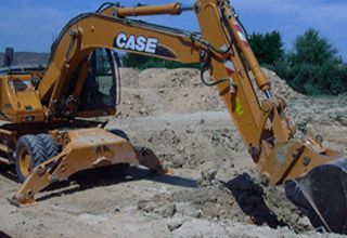 Una excavadora está cavando un hoyo en la tierra.