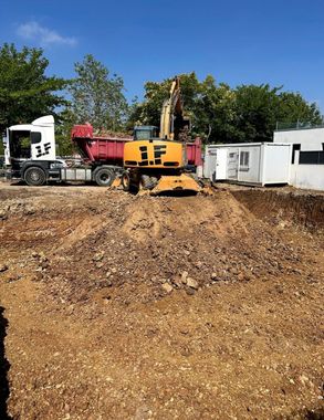 Una excavadora y una retroexcavadora están trabajando en un sitio de construcción.