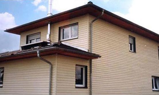 Kraus & Schwarz Holzbau GmbH, Leinburg-Diepersdorf, Balkonanlagen, Anbau im nordischen Stil mit integrierter Balkonanlage und Gaubenfassade in weiss als Boden-Deckenschalung. Holzterrasse in Garapa Holz.