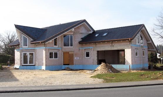 Kraus & Schwarz Holzbau GmbH, Leinburg-Diepersdorf, Balkonanlagen, Anbau im nordischen Stil mit integrierter Balkonanlage und Gaubenfassade in weiss als Boden-Deckenschalung. Holzterrasse in Garapa Holz.