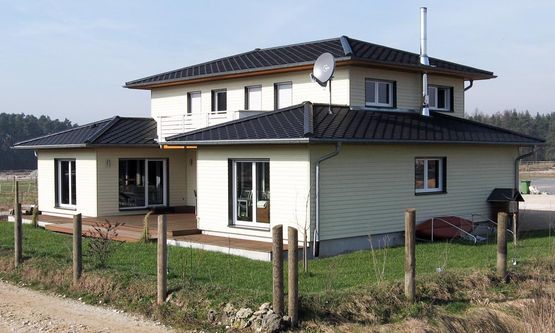 Kraus & Schwarz Holzbau GmbH, Leinburg-Diepersdorf, Balkonanlagen, Anbau im nordischen Stil mit integrierter Balkonanlage und Gaubenfassade in weiss als Boden-Deckenschalung. Holzterrasse in Garapa Holz.