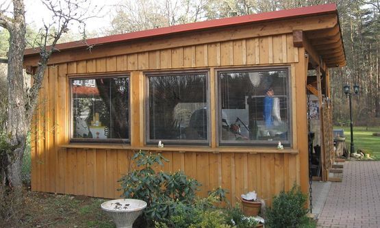 Kraus & Schwarz Holzbau GmbH, Leinburg-Diepersdorf, Balkonanlagen, Anbau im nordischen Stil mit integrierter Balkonanlage und Gaubenfassade in weiss als Boden-Deckenschalung. Holzterrasse in Garapa Holz.