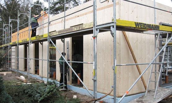 Kraus & Schwarz Holzbau GmbH, Leinburg-Diepersdorf, Balkonanlagen, Anbau im nordischen Stil mit integrierter Balkonanlage und Gaubenfassade in weiss als Boden-Deckenschalung. Holzterrasse in Garapa Holz.