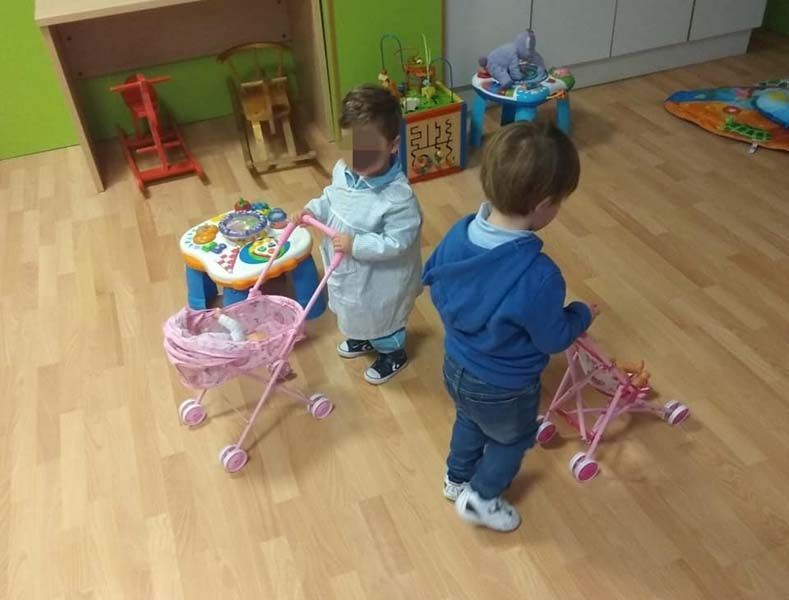 Dos niños están jugando con juguetes en una habitación.
