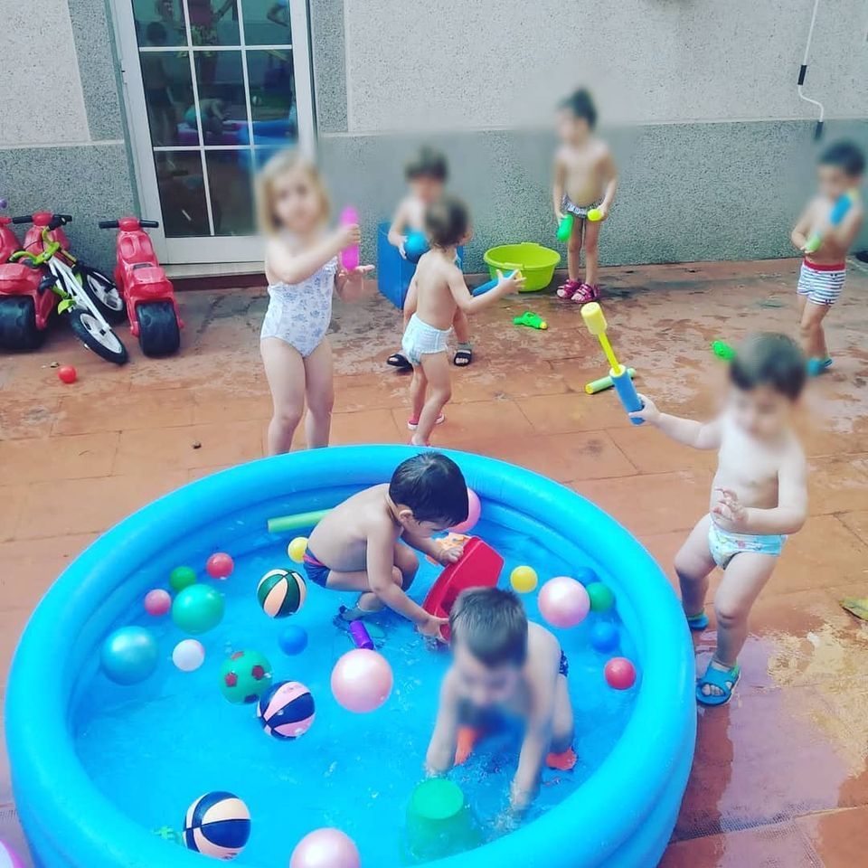 Un grupo de niños está jugando en una piscina inflable.