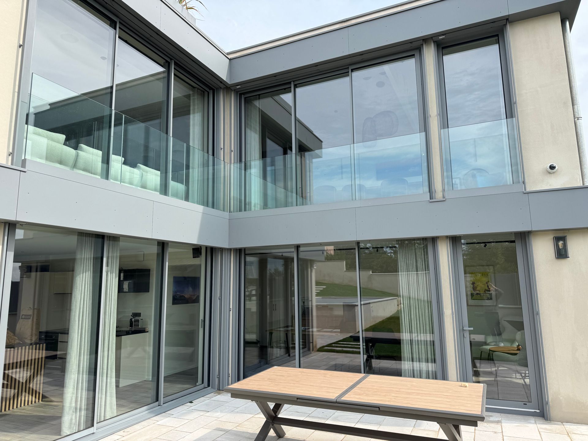 Immeuble moderne avec de grandes baies vitrées et un balcon, vue extérieure.