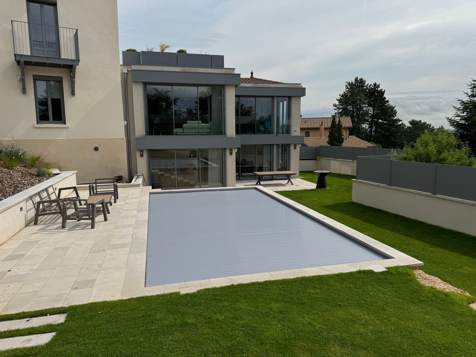 Maison moderne avec piscine et terrasse couverte.