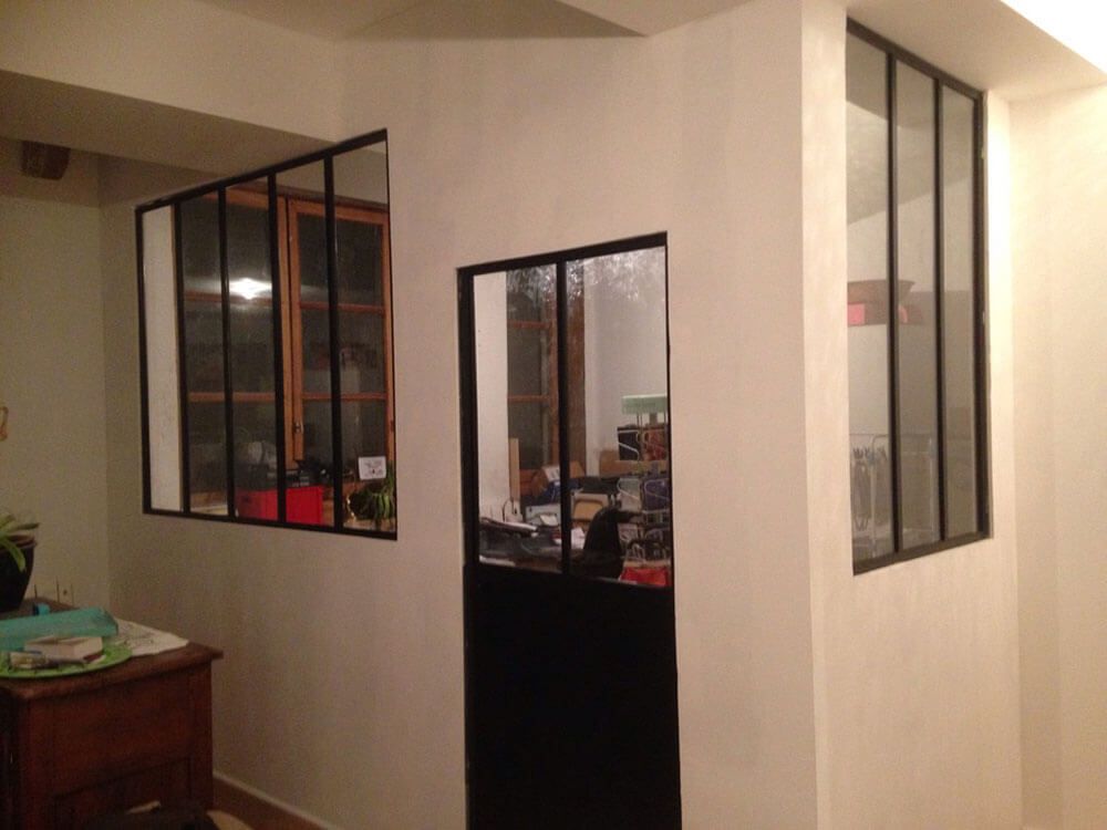 Pièce blanche avec fenêtres à cadre noir et porte. Vue intérieure.