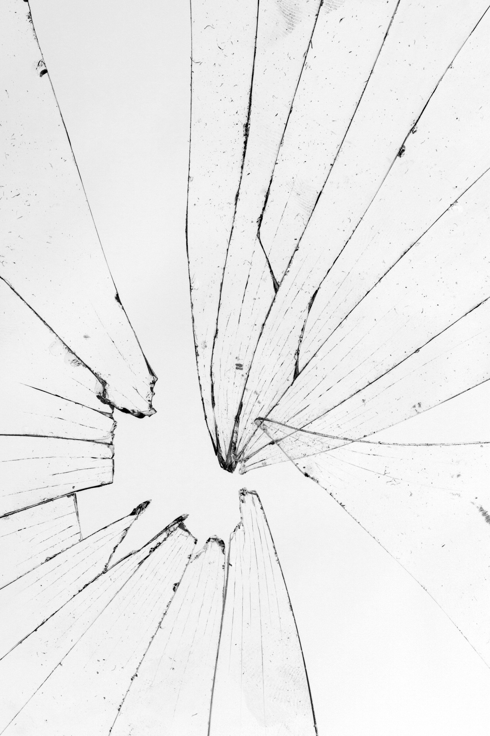 Vitre brisée présentant des fissures radiales partant d'un point d'impact central.