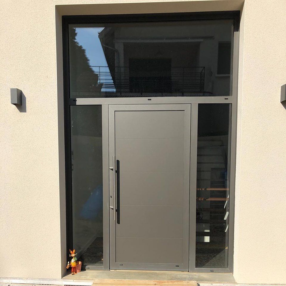 Porte d'entrée encadrée par des vitres