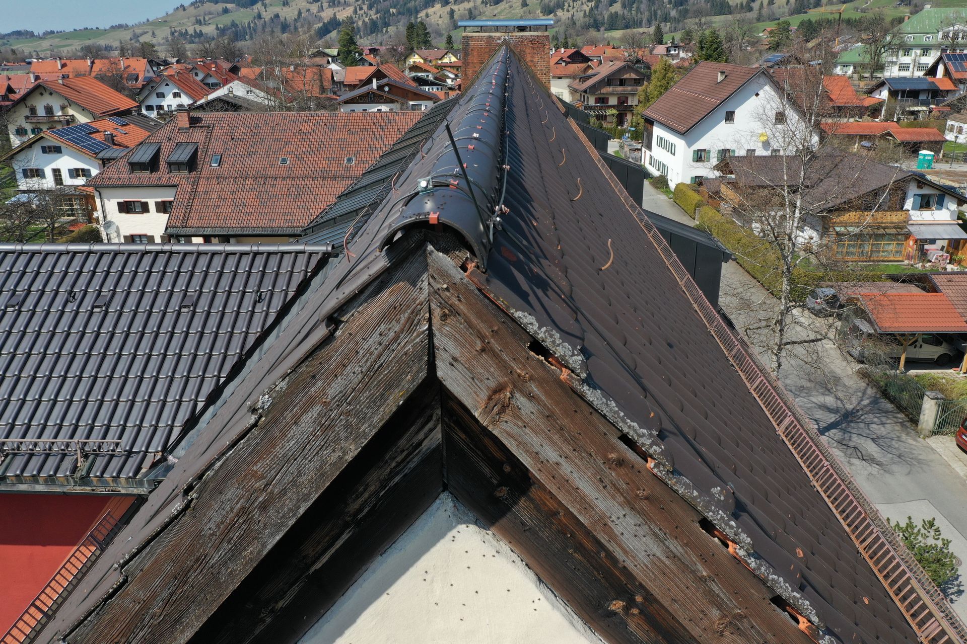 Hochbauten: Dach eines Wohngebäudes mit umliegender Bebauung.