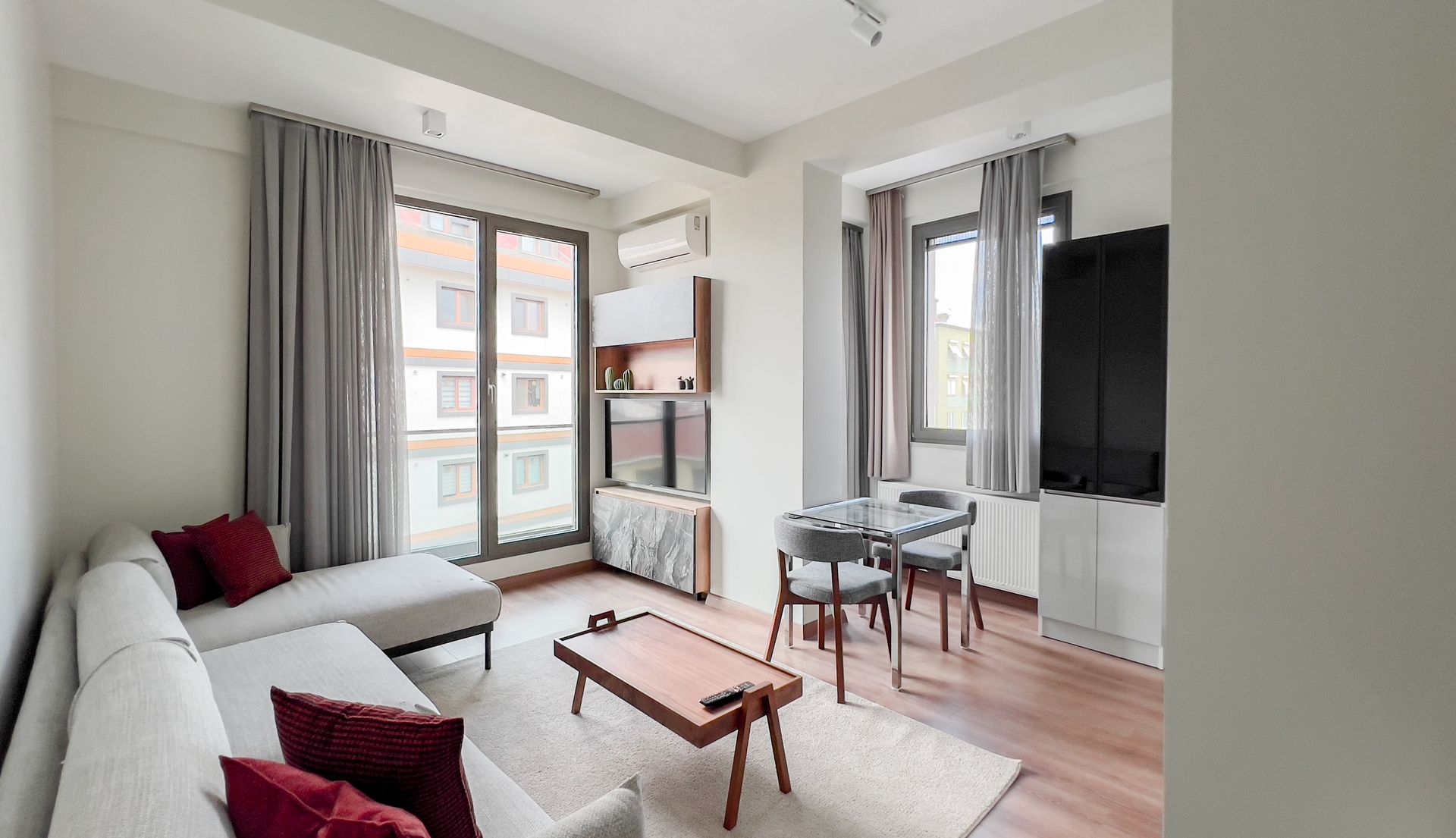 A living room with a couch , table , chairs and a television.