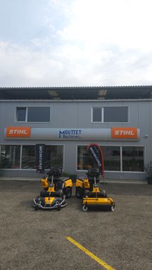 Souffleuse à neige devant un bâtiment avec un panneau indiquant « machines ».