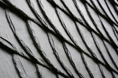 Eine Nahaufnahme eines schwarzen Schieferdachs mit einem diagonalen Muster