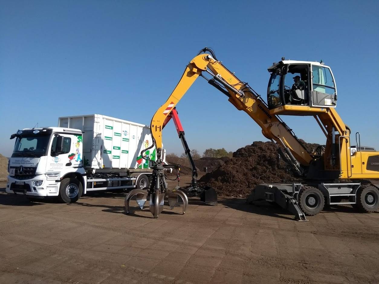 URD LKW mit Krancontainer und Umschlagbagger
