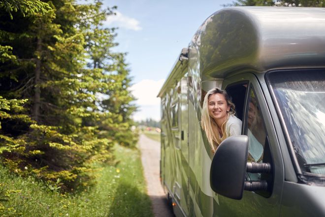 Eine Frau schaut aus dem Fenster eines Wohnmobils.