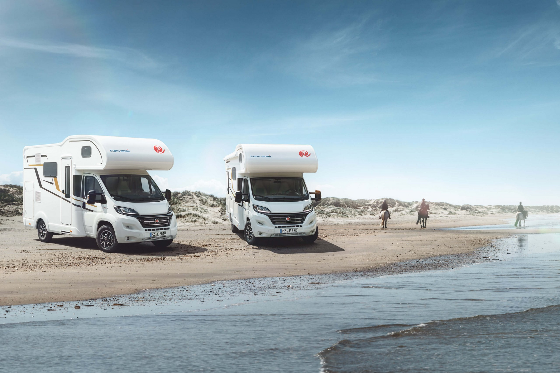 Zwei wohnmobile stehen nebeneinander am strand.