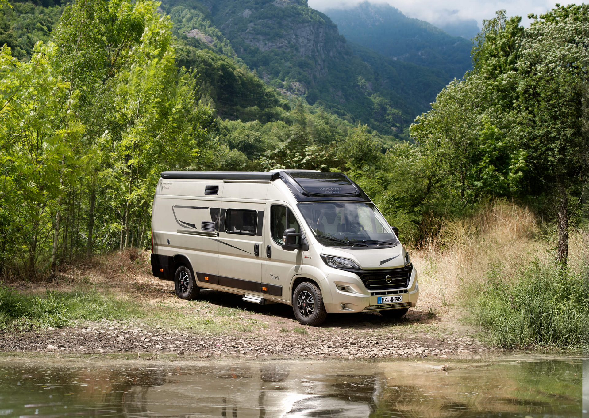 Ein Wohnmobil ist am Ufer eines Flusses geparkt.